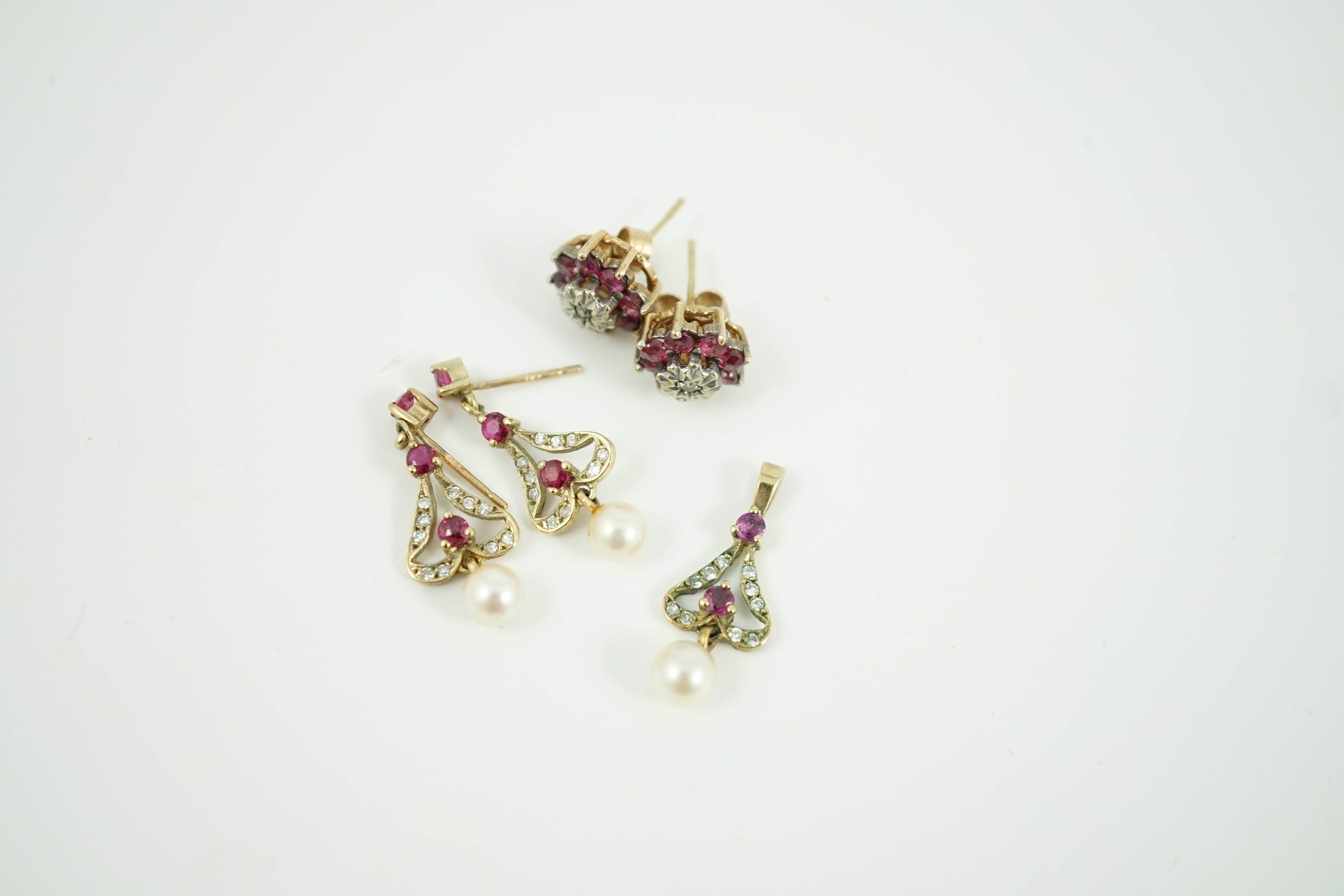 A modern 9ct gold, ruby, diamond and cultured pearl set drop pendant, 22mm and a pair of matching earrings, together with a pair of ruby and diamond cluster set ear studs, gross weight 5.7 grams.